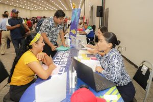 Buscadores de empleo interactúan con representantes de empresas en la Segunda Feria del Empleo Tampico 2024, explorando oportunidades laborales.